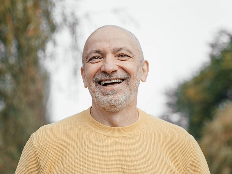 Older man smiling after replacing missing teeth with dental implants